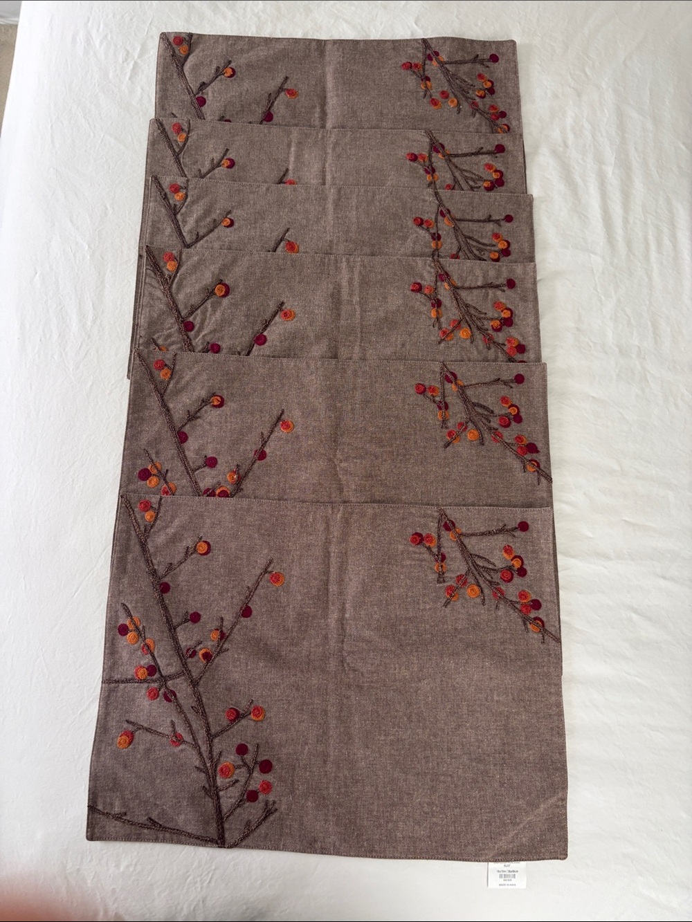 Crate&Barrel Embroidered Placemats with Shades of oranges and reds.